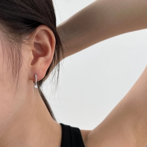 Close-up of S925 sterling silver hoop earrings with heart-shaped cubic zirconia on model