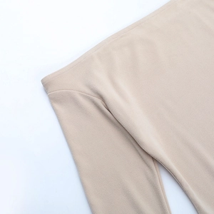 Close-up of fine knitting and stitching on the waist of a slim beige bodycon dress
