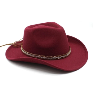 Close-up of wine red western cowboy hat with rhinestone studded leather band and tassels