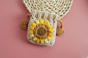 Close-up of handmade sunflower crochet drawstring bag with heart-shaped cord accents