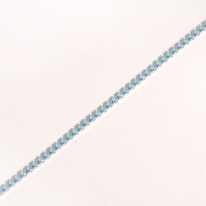 Detail of silver chain bracelet with claw-set blue round cubic zirconia stones