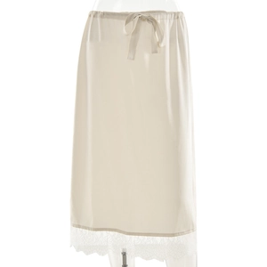 Détail d'une jupe en satin crème avec bordure en dentelle délicate et taille à cordon