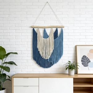 Bohemian hand-woven wall tapestry with colorful blue tassels on a natural wood pole