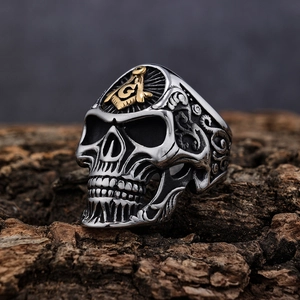 Vintage silver Viking skull ring with gold Freemason logo on rustic wood background