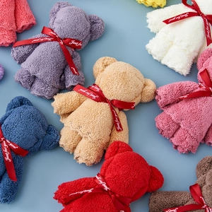 Overhead view of various colorful bear-shaped coral fleece towels with Just for you ribbons