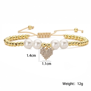 Detail showing 1.4cm zircon heart pendant and adjustable gold bead pearl bracelet