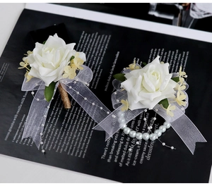 Détail de la boutonnière de rose blanche et du corsage de poignet en perles pour mariage