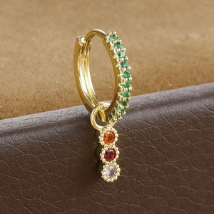 Detail of gold drop earrings with green zircon band and dangling multi-color gems
