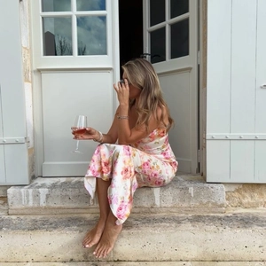 Robe longue fleurie à fines bretelles en dentelle dans un décor de vacances romantique
