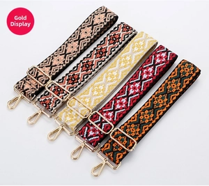 Detailed view of bohemian style woven canvas bag straps with gold hardware and embroidery