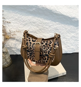 Detail of trendy leopard print shoulder bag with brown patchwork and metallic buckle