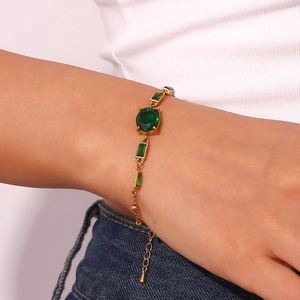 Bracelet en acier inoxydable plaqué or 18K avec pierres ovales vert émeraude sur modèle