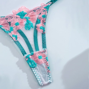Detail of floral lace embroidery and mesh fabric on turquoise lingerie panties
