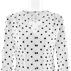 Detailed close-up of white V-neck polka dot blouse with button closure and chiffon texture