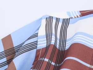 Detailed close-up showing the blue and brown plaid fabric texture and shoulder stitching