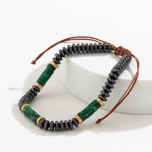 Detail of beaded bracelet with hematite, malachite texture, and adjustable cord