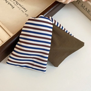 Vue détaillée de la pince à cheveux en tissu rayé avec texture vintage et design superposé