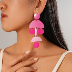 Dettaglio di orecchini rosa geometrici con pendenti circolari in resina sul modello
