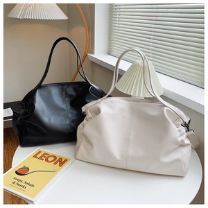 Detalle de textura de cuero PU suave en bolsos grandes de color negro y beige