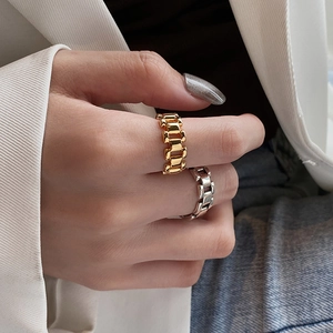 Unisex gold and silver chain link rings shown in a minimalist fashion lifestyle setting