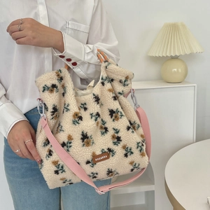 Detail of floral shearling tote bag featuring pink strap and orange checkered handles