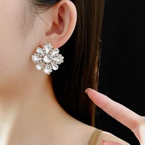 Close-up of model wearing silver flower earrings with crystals in a vintage style