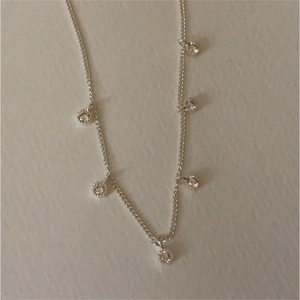 Detail of S925 sterling silver chain featuring six round bezel-set zircon pendants