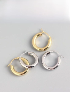 Detail of 18K gold and silver hoop earrings featuring a vacuum plated metallic texture