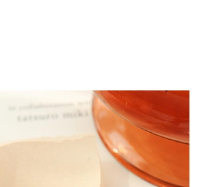 Detailed view of an amber glass jar with cosmetic liquid and beige branding label
