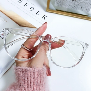 Modern oversized transparent blue light blocking glasses shown in a lifestyle hand-held shot