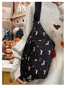 Close-up of black crossbody bag with cute cartoon dog print and adjustable strap