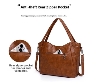 Detail view of the rear anti-theft zipper pocket on a brown faux leather tote bag