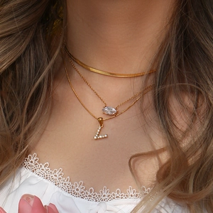 Close-up of triple-layered 18K gold-plated necklace with letter L and marquise zircon