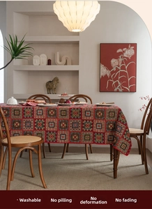 Detailed texture of red geometric jacquard tablecloth with washability and durability icons