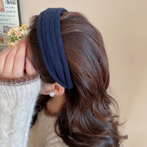Vue détaillée du bandeau tricoté bleu foncé avec texture verticale sur un modèle