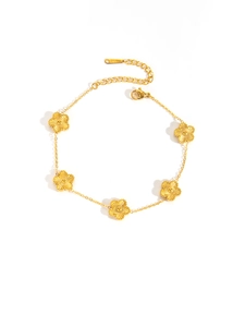 Detail of gold flower bracelet with radial textures and engraved S-STEEL steel tag