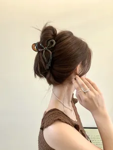 Close-up of tortoise shell pattern bow hair claw clip worn on a woman's hair
