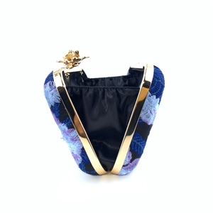 Detail of blue floral embroidery and golden flower clasp on the vintage evening clutch bag