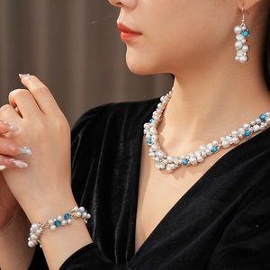 Modella che indossa un set di gioielli vintage con perle, pietre blu e cristalli lucidi
