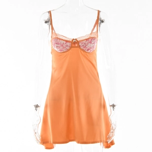 Dettaglio sottoveste in raso arancione con coppe in pizzo floreale rosa e spalline sottili