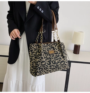 Detail of leopard print tote bag with brown PU leather strap and gold chain detail