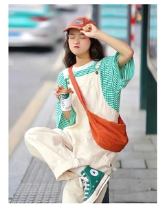 Vibrant orange nylon crescent crossbody bag styled with a summer casual college outfit
