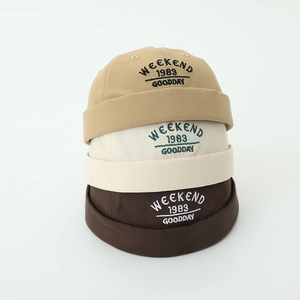 Three children's docker caps in khaki, beige, and brown with 1983 letter embroidery