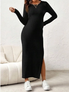 Detail of a slim-fit black knit maternity dress with a side slit and ribbed texture