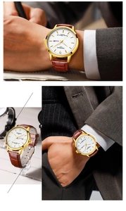 Detail of gold watch with white dial, brown leather strap and dual calendar display