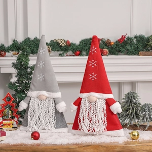 Christmas forest gnome dolls in red and grey with snowflake hats on snow tabletop