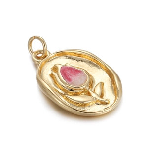 Detail of a gold-plated oval locket featuring a pink tulip inlay and matte metal texture