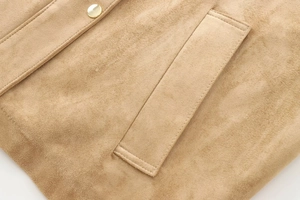 Detailed macro view of khaki suede jacket fabric texture with golden metal snap button