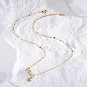 Elegant gold LOVE necklace with sparkling zircons and heart pendant on white stone