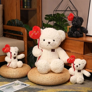 Group of black and white plush teddy bears holding red heart balloons in a cozy room
